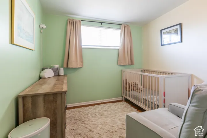 Window with blinds and curtains, wood-finish flooring, and light-toned wall finishes