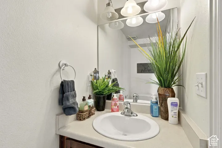 Vanity with an integrated sink, polished chrome faucet, and a wall-mounted mirror