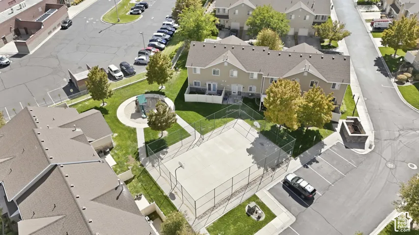 Townhome community featuring a basketball court, playground, and paved parking areas