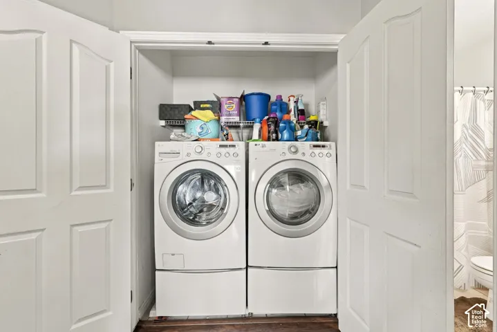 Built-in laundry area with double-door entry, featuring front-loading washer and dryer units, and an overhead wire shelf