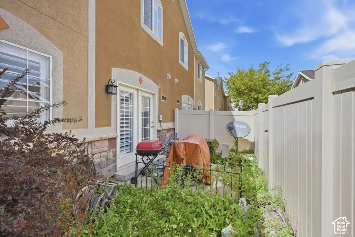 Stucco exterior with stone accent, French doors with louvered blinds, and a private enclosed patio