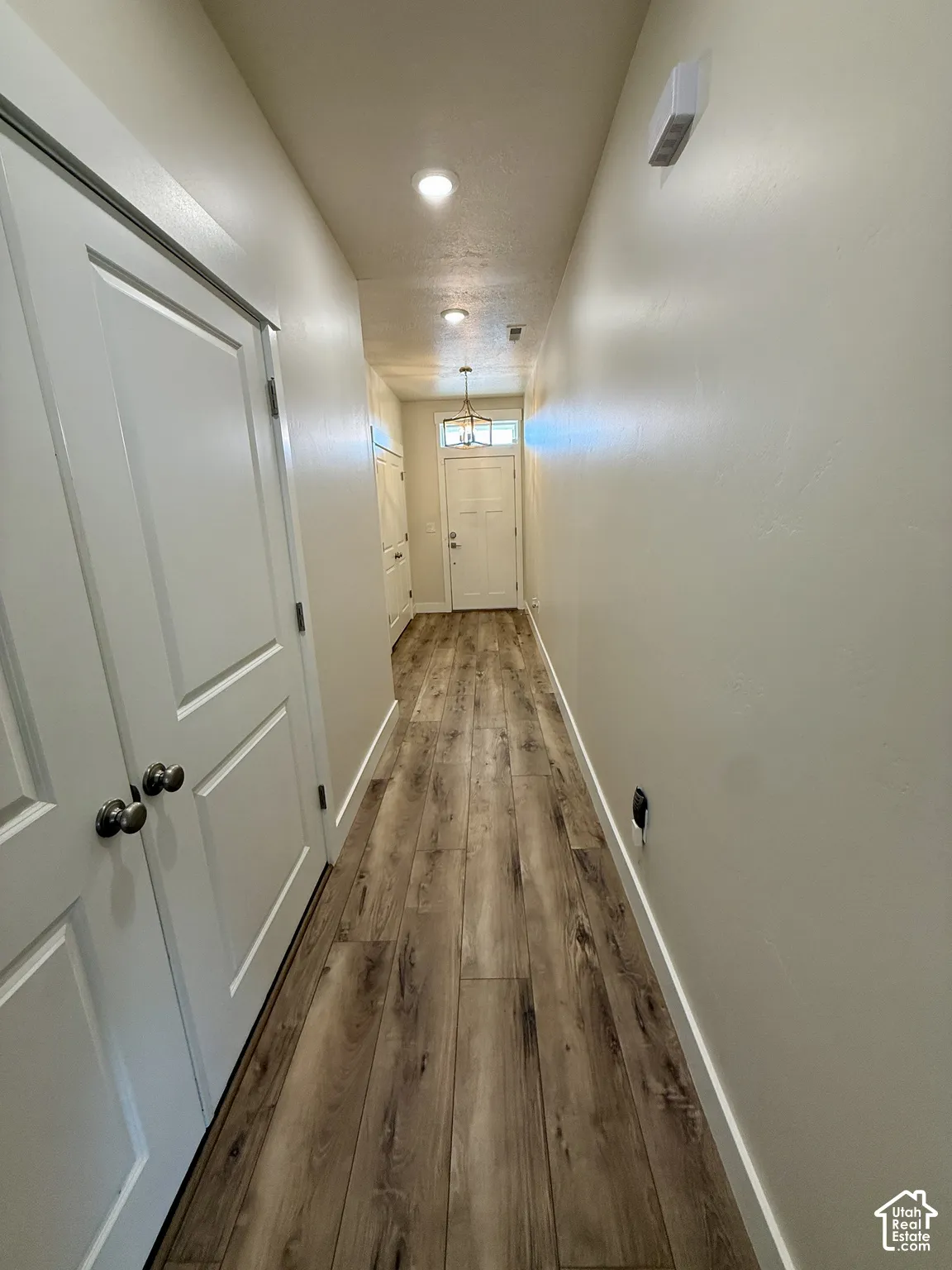 Wood-finish flooring, recessed lighting, and a front entry door with transom window