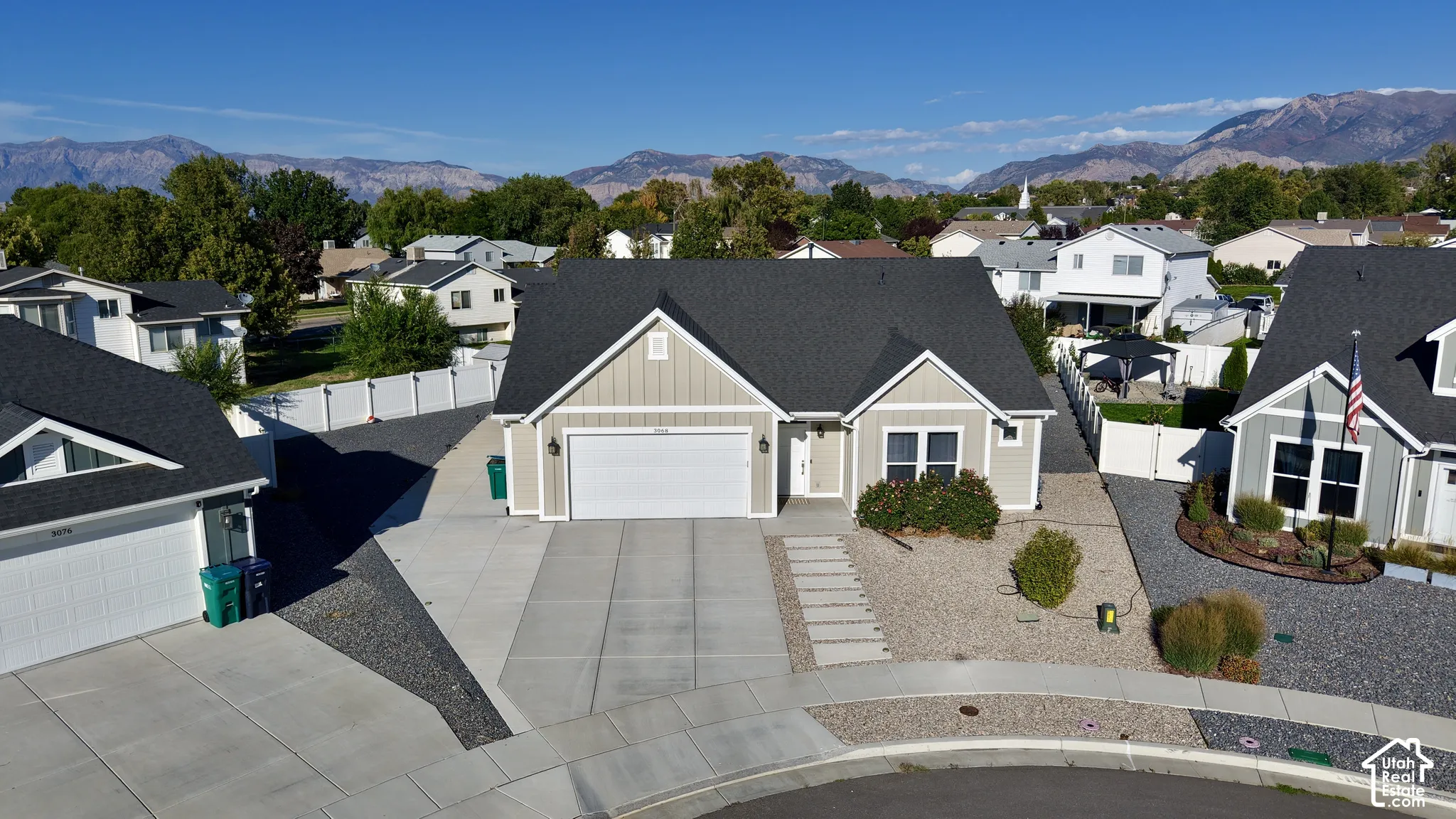 Single-story residence featuring a gray shingle roof, light-colored siding, and a two-car garage