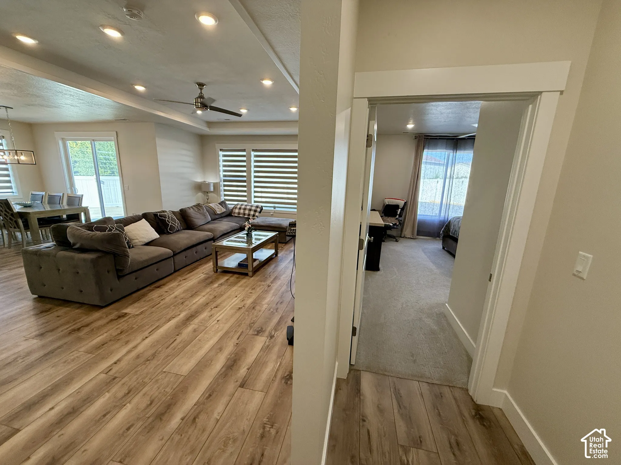 Open-concept living space with wood-finish flooring, recessed lighting, and a ceiling fan