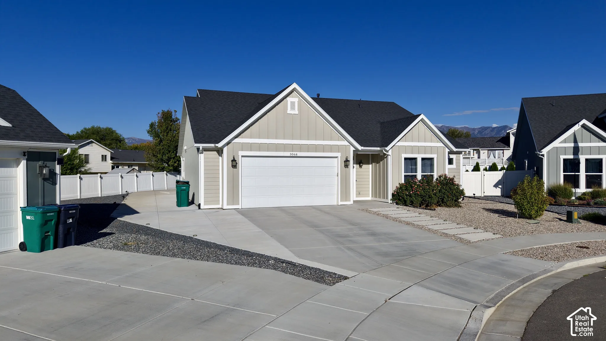 Single-story residence featuring light neutral siding and dark shingle roofing