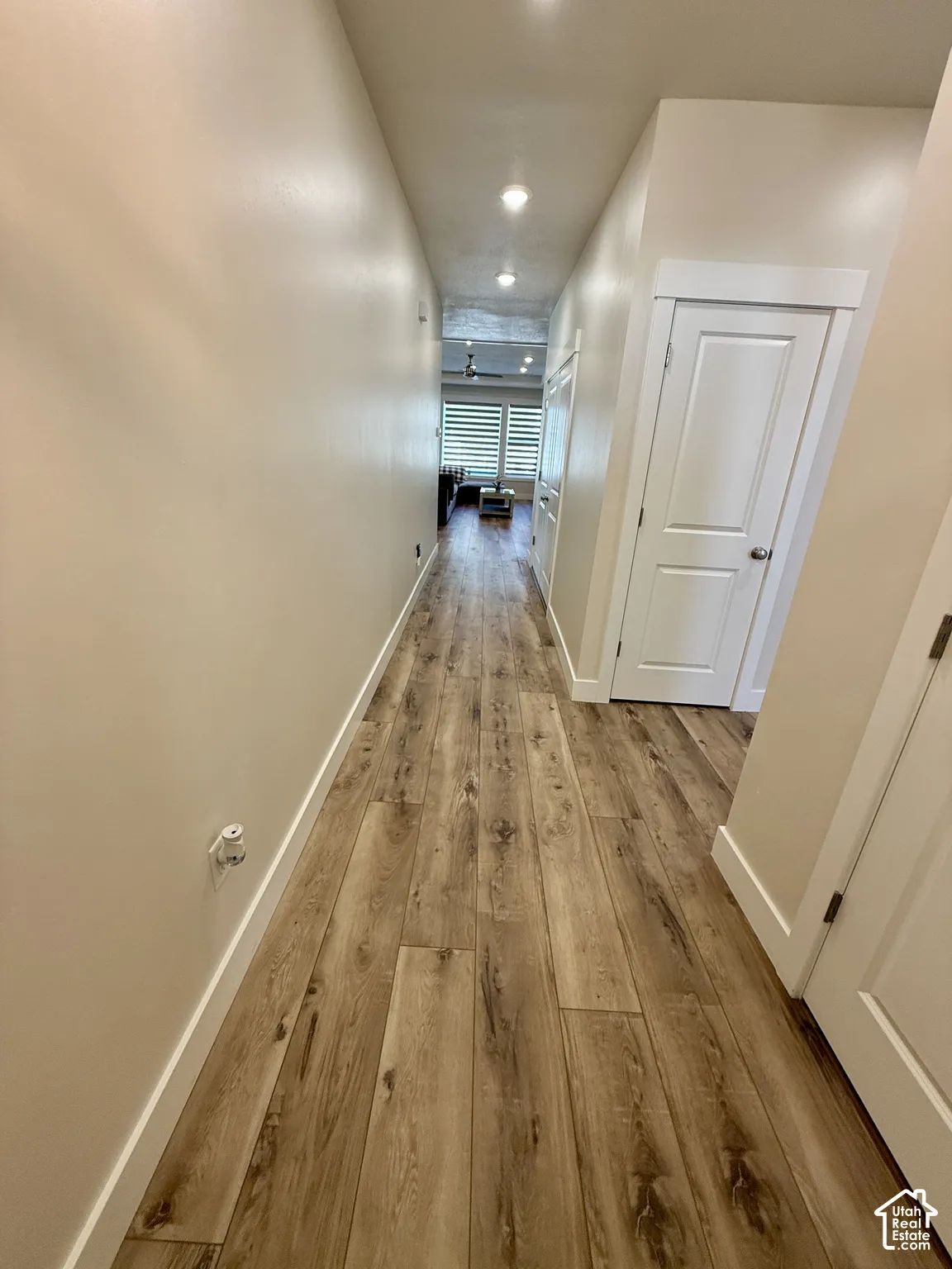 Wood-finish flooring throughout, recessed ceiling lighting, and crisp white trim details
