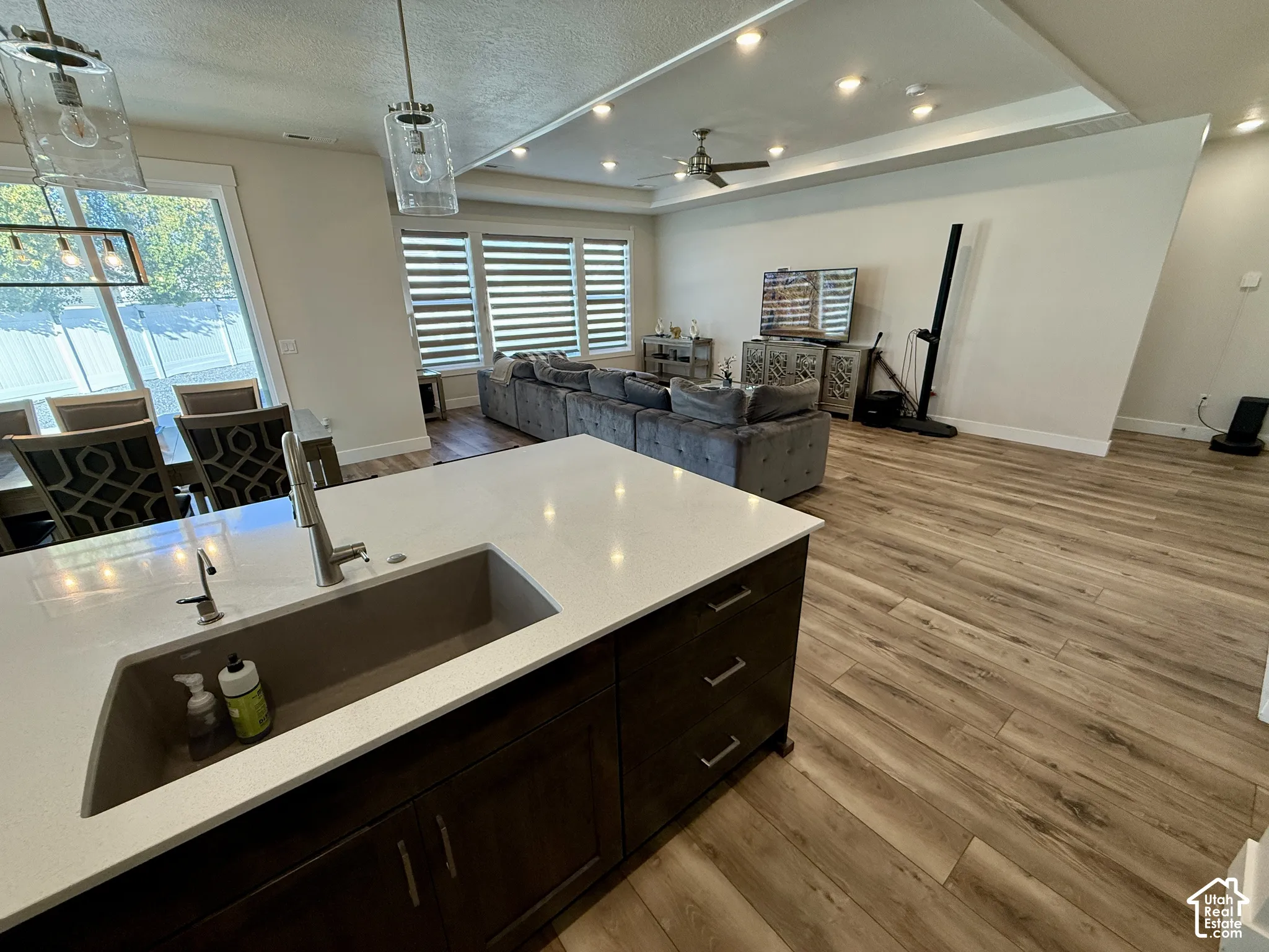 Kitchen island with an undermount sink, a gooseneck faucet, and light-toned countertops