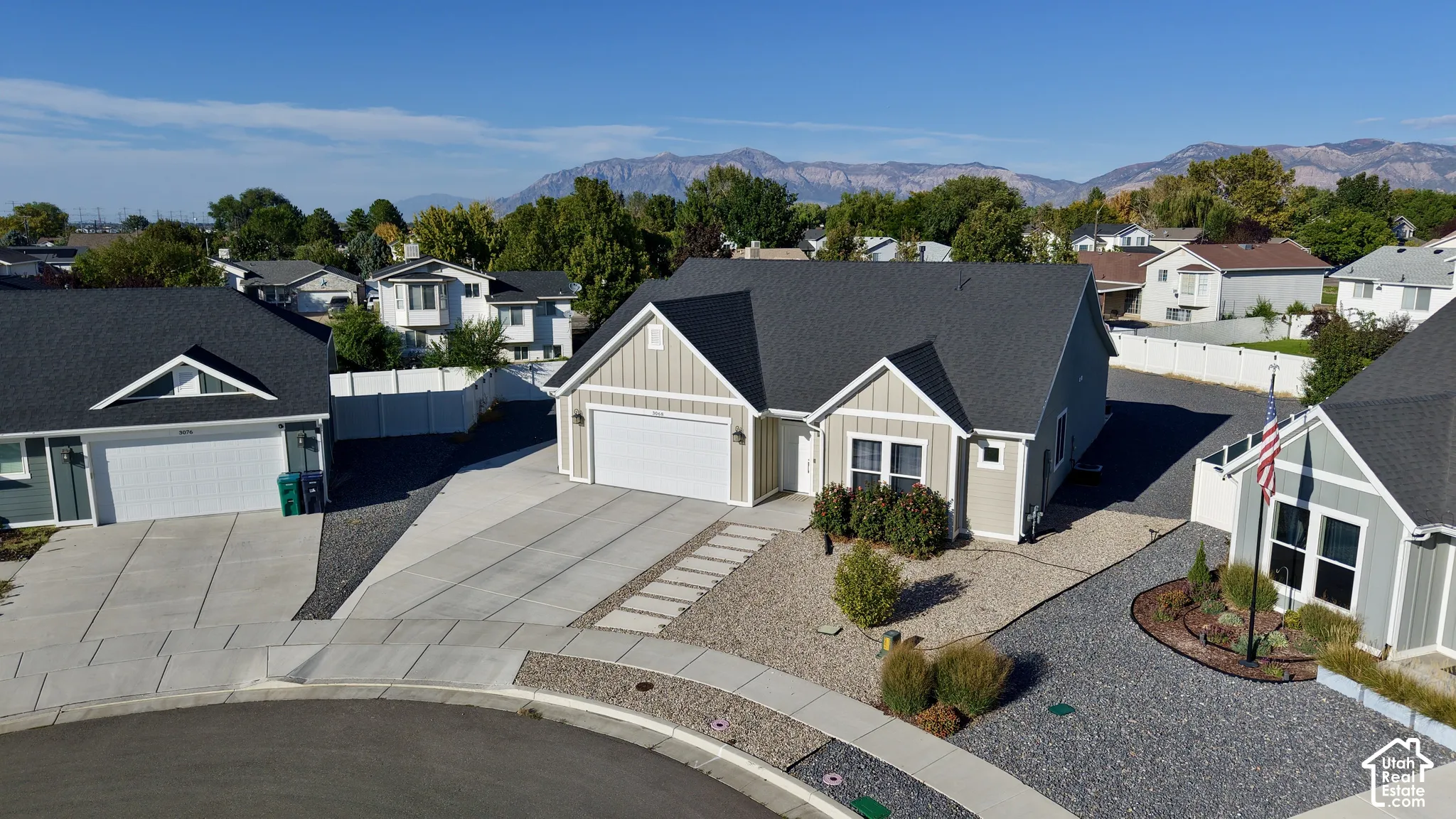 Contemporary residence with a dark shingle roof, light-toned siding, and a two-car garage