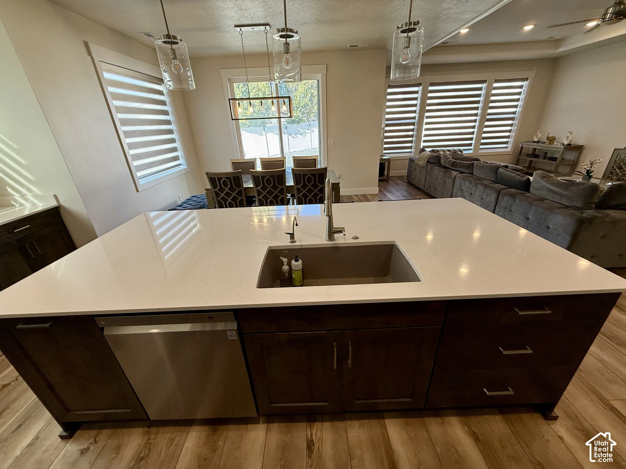 Spacious kitchen island with a built-in sink, stainless steel dishwasher, and ample storage cabinetry