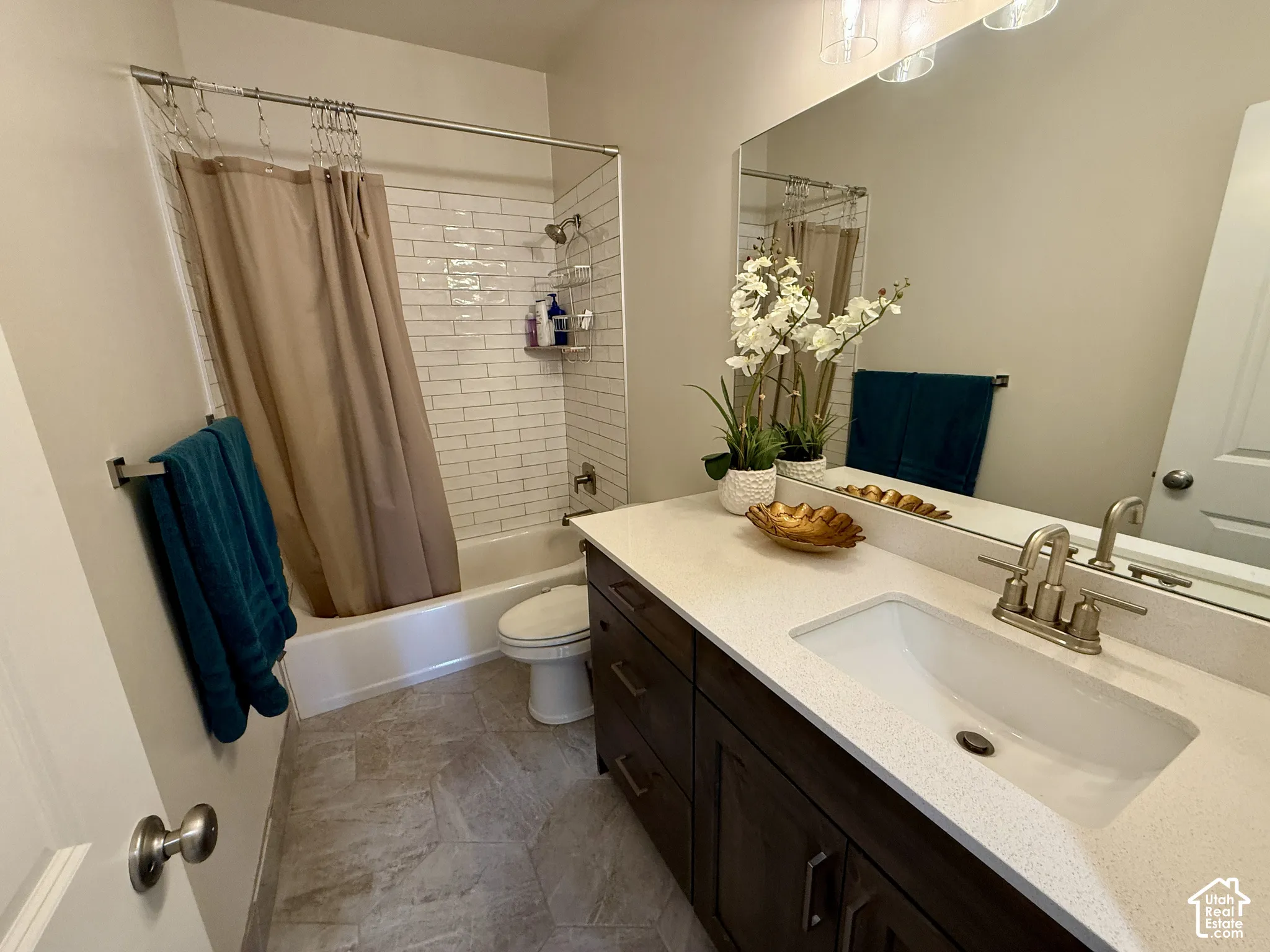 Vanity with an integrated rectangular sink, speckled countertop, and brushed nickel faucet