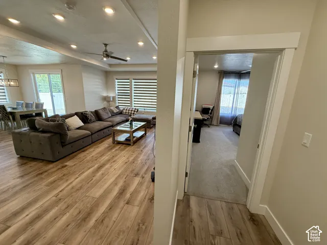 Open-concept living space with wood-finish flooring, recessed lighting, and a ceiling fan