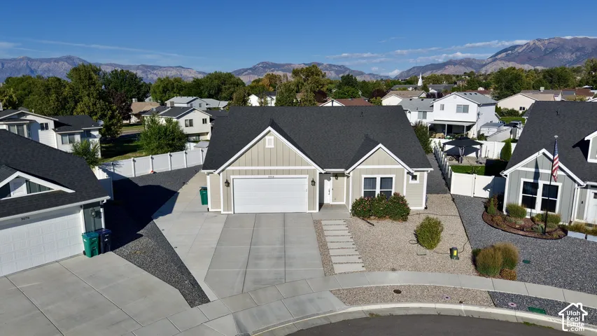 Single-story residence featuring a gray shingle roof, light-colored siding, and a two-car garage