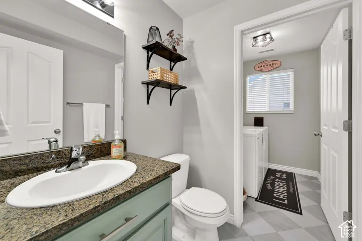 Half-bath with new flooring and light-colored cabinetry