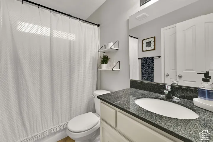 Vanity with a granite countertop, undermount sink, and chrome faucet