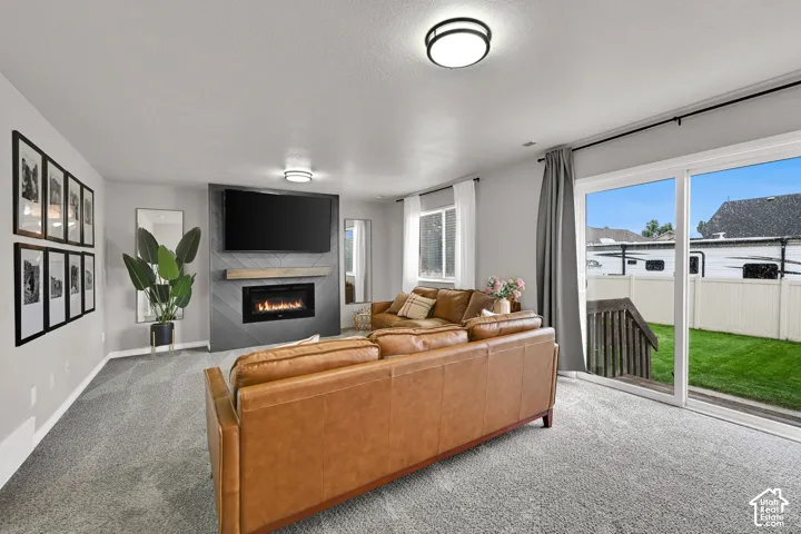 Contemporary living space featuring a built-in fireplace with a chevron-patterned surround, wood mantel, and sliding glass door