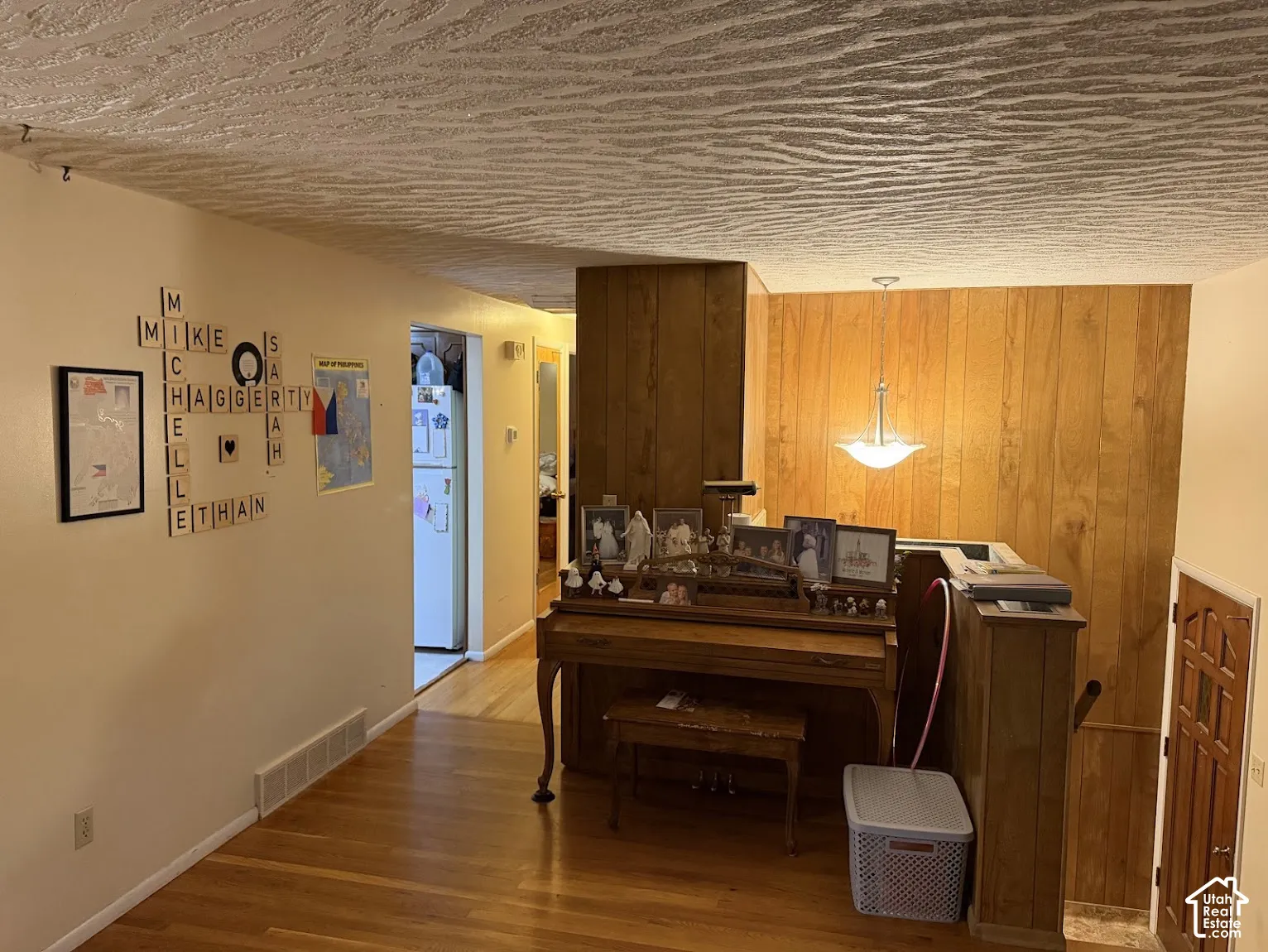 Wood-finish flooring, wood paneling, recessed lighting, and a paneled entry door