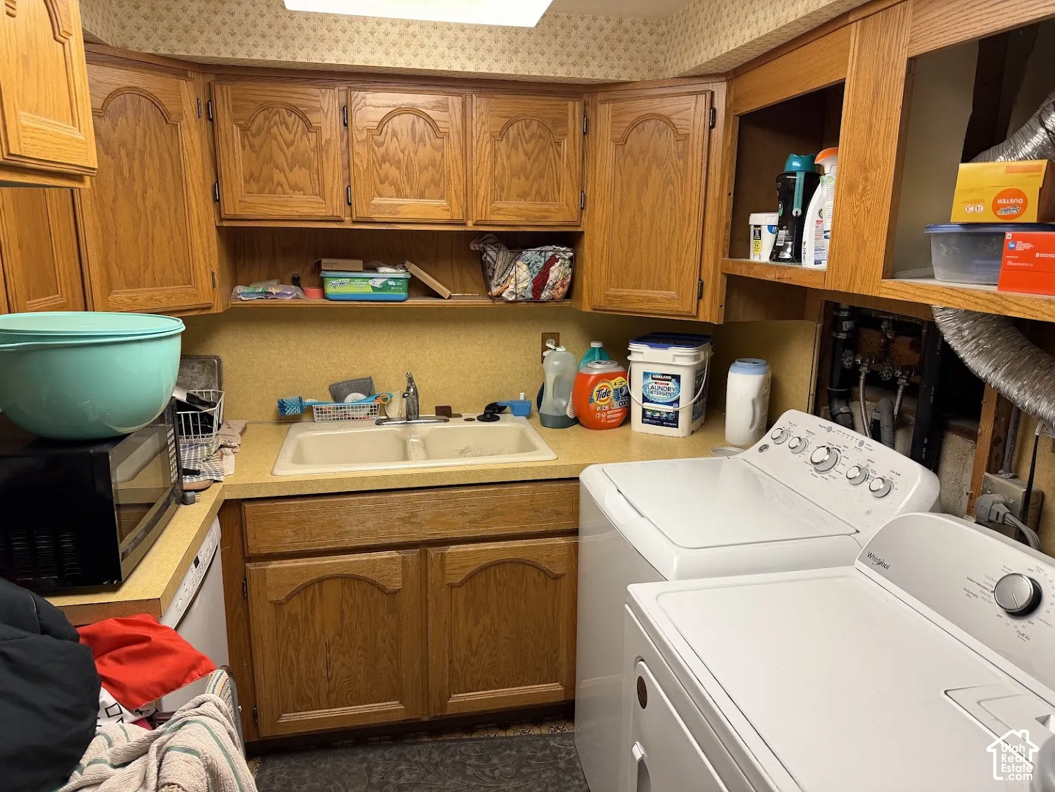 Wood-finish cabinetry, double basin sink, and ample countertop space