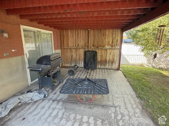 Covered patio with exposed wood beams and concrete flooring