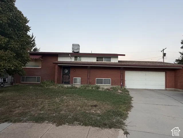 Brick exterior with a prominent two-car garage, concrete driveway, and covered entry