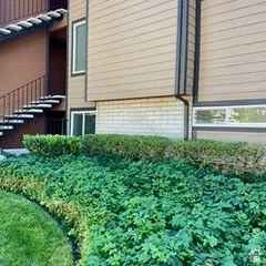 Exterior featuring horizontal siding, brick base, black metal railing, and an exterior staircase
