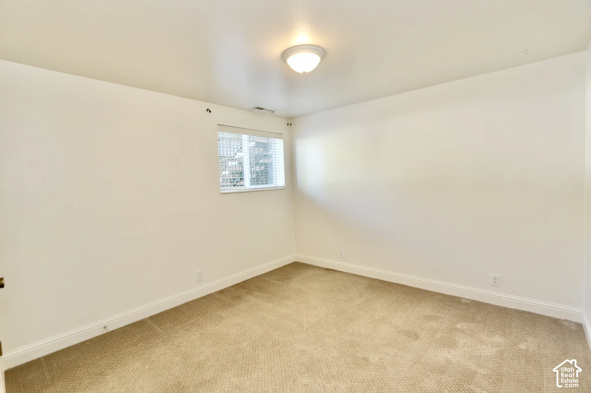 Recessed window with horizontal blinds, carpeted flooring, and a flush mount ceiling light