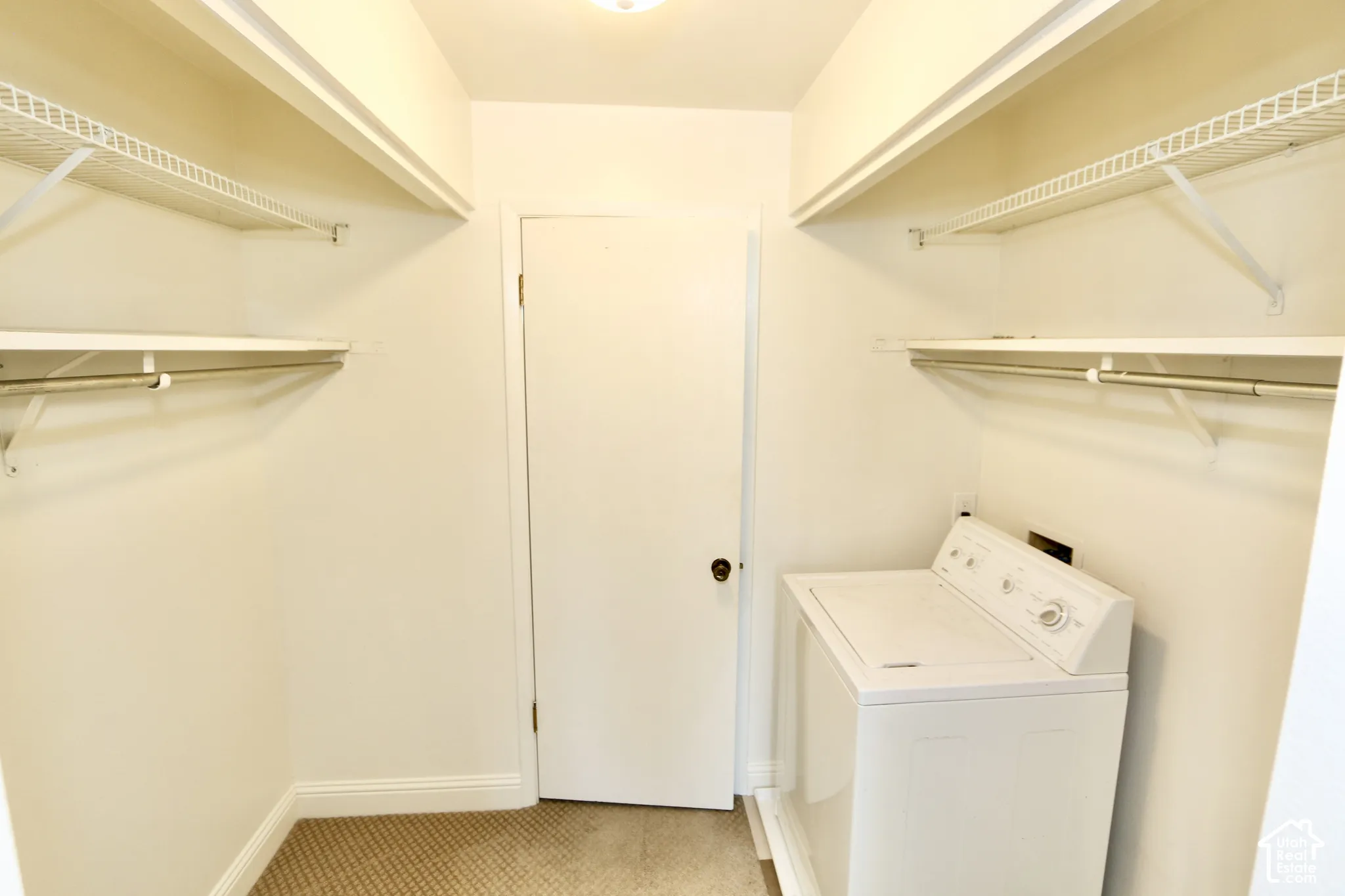 Master closet with laundry area featuring a top-load washing machine, built-in wire shelving, and carpeted flooring