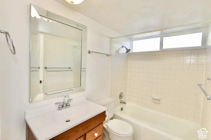 2nd bathroom with beveled mirror vanity with a white countertop and bathtub shower combination.
