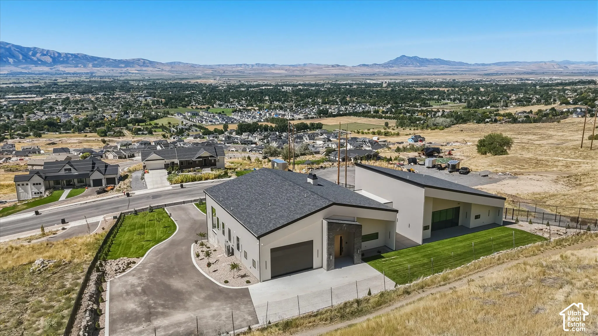 Contemporary architecture with a sloped roofline, attached garage, and stone-accented entry