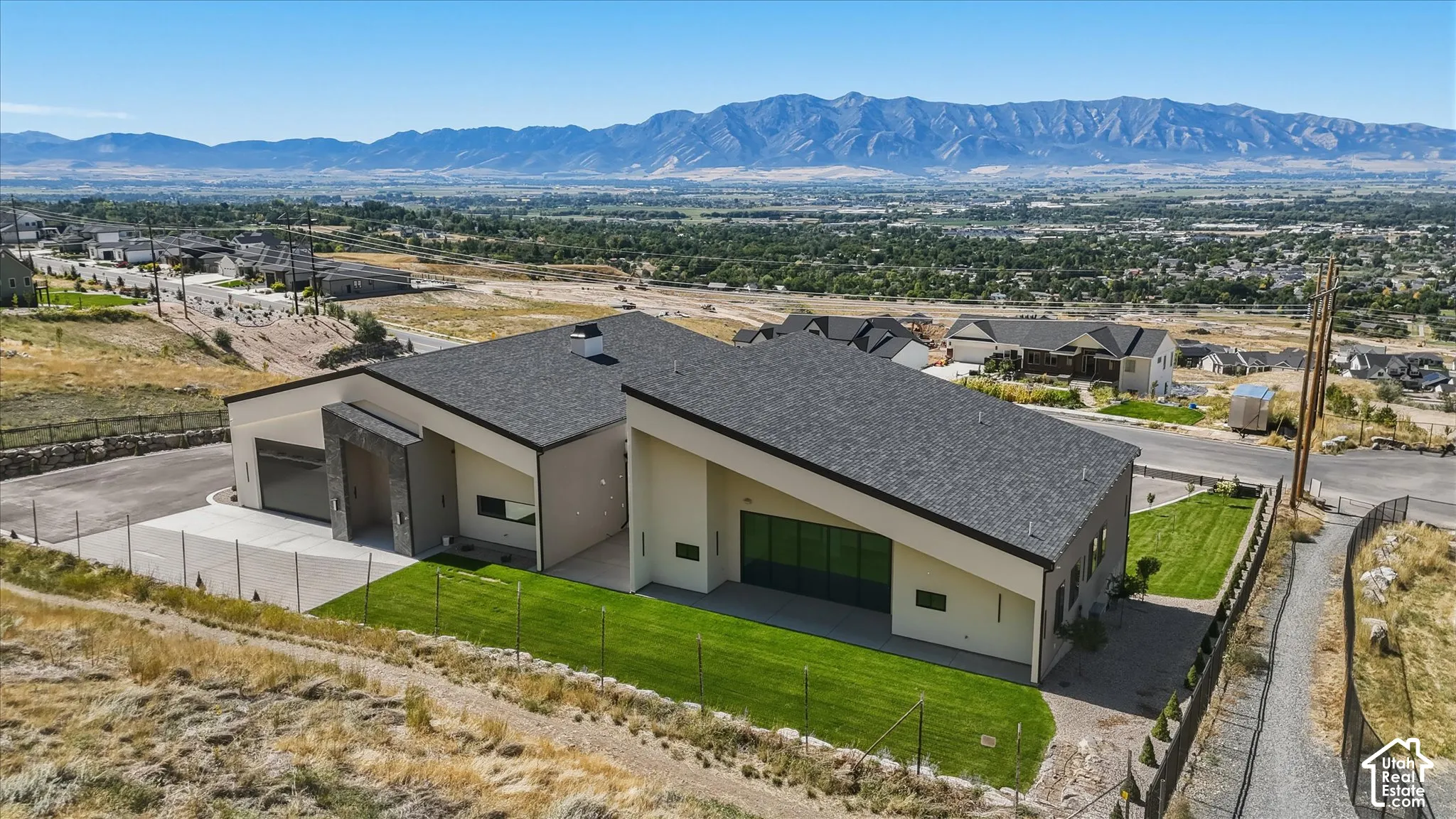 Modern architectural design with a dark shingle roof and a light-toned stucco exterior