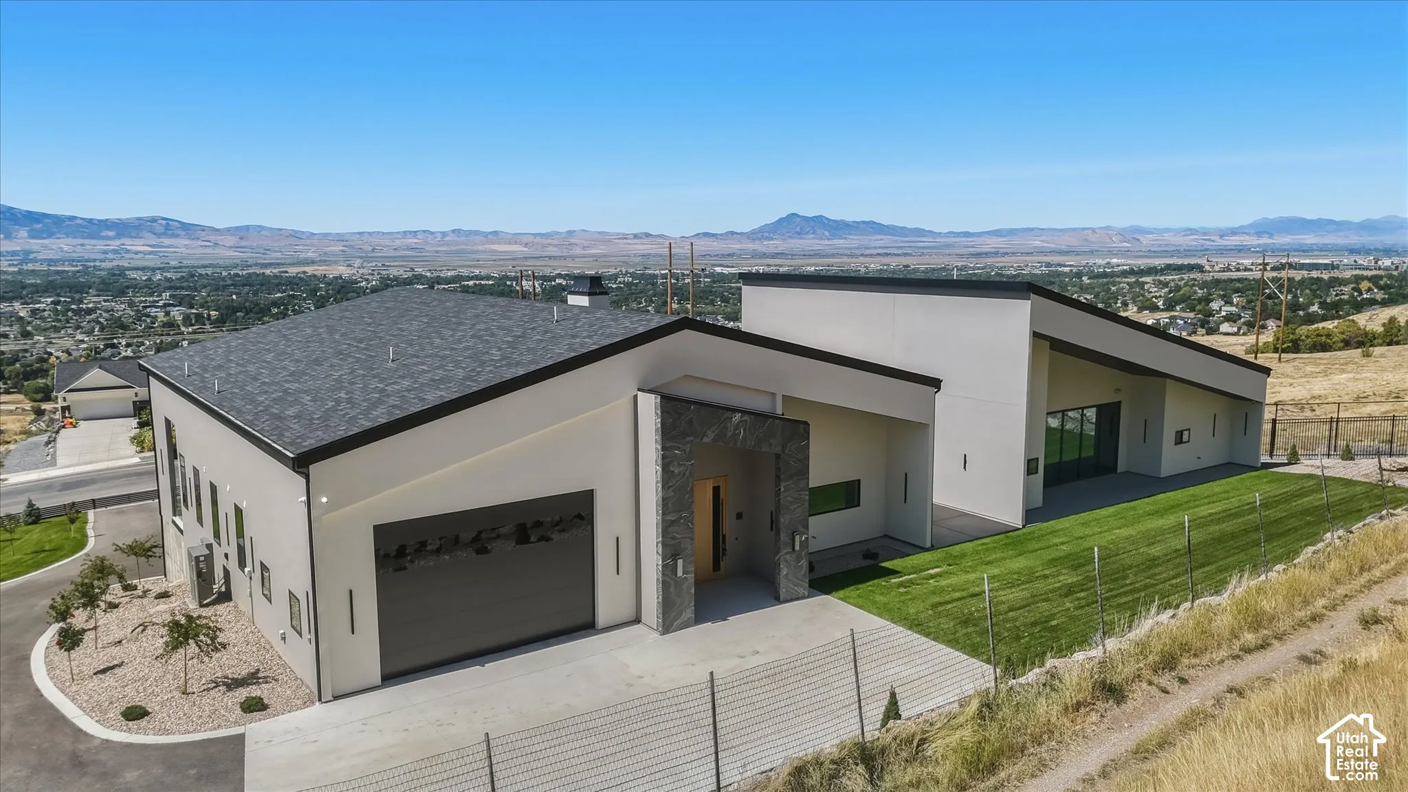 Modern architectural style with a contrasting stone façade entry and a large attached garage