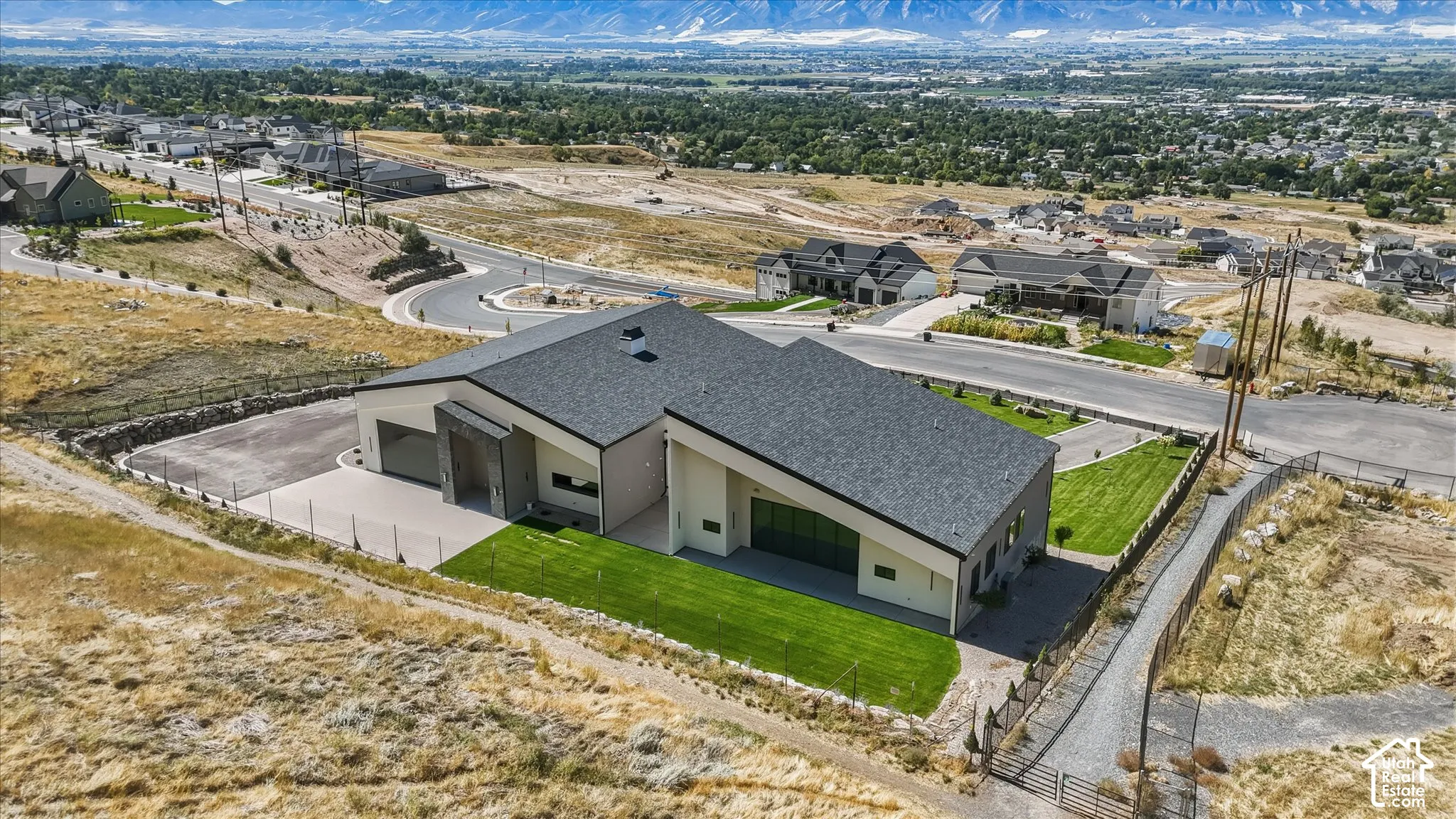 Modern architectural design featuring a multi-pitched roofline and expansive green lawn