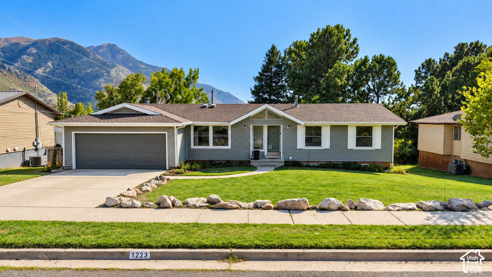 Ranch-style residence featuring a gray exterior and attached garage