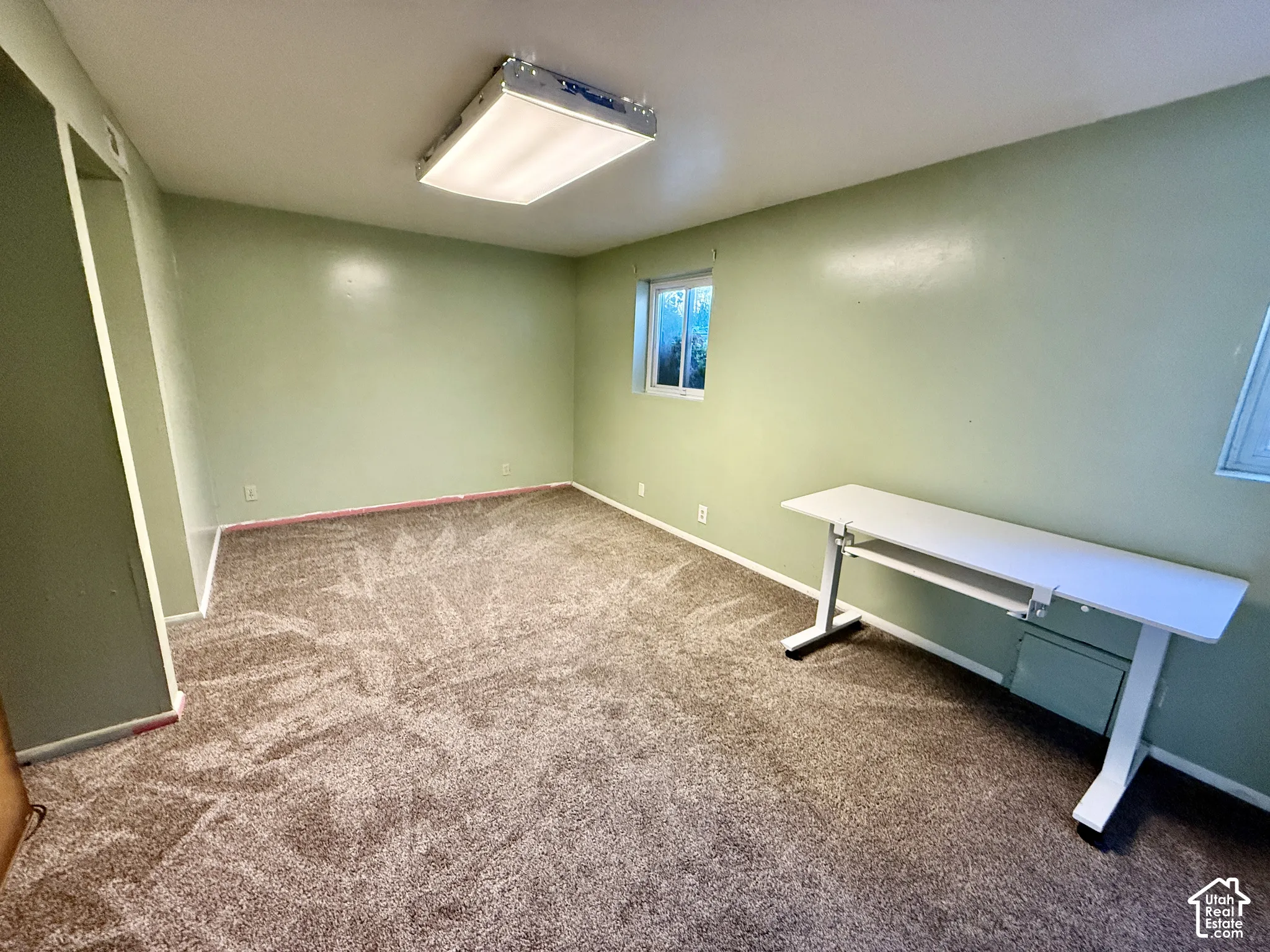 Recessed window, textured carpet flooring, and a flush-mounted ceiling light fixture
