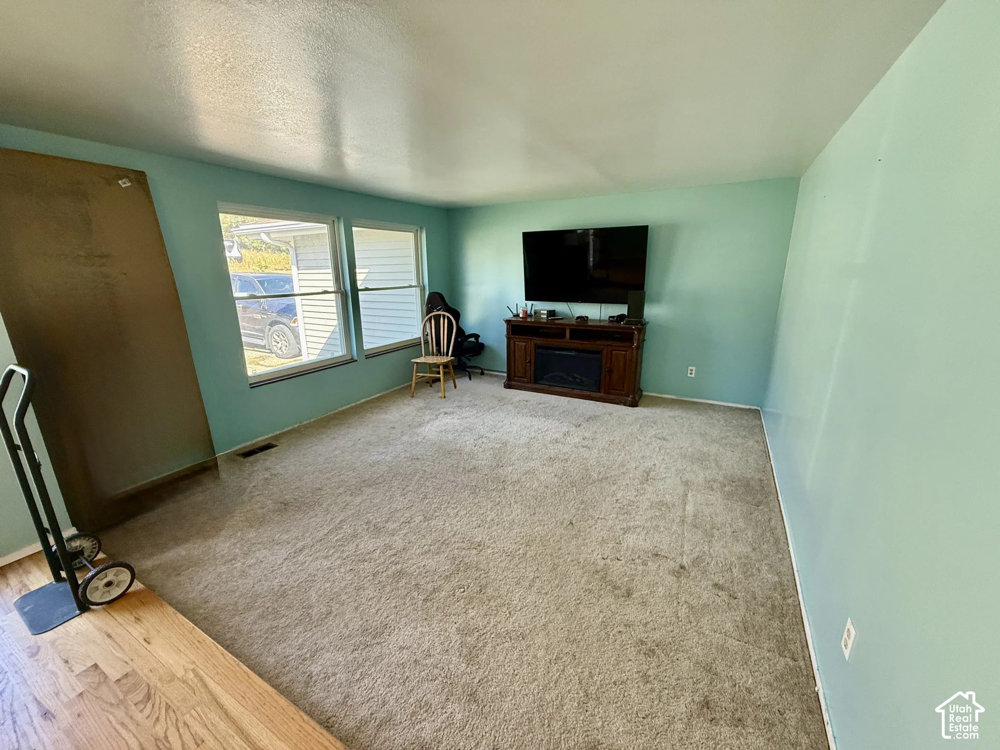 Two large windows, wood-finish flooring, and a built-in electric fireplace