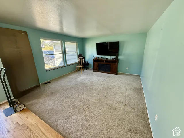 Two large windows, wood-finish flooring, and a built-in electric fireplace