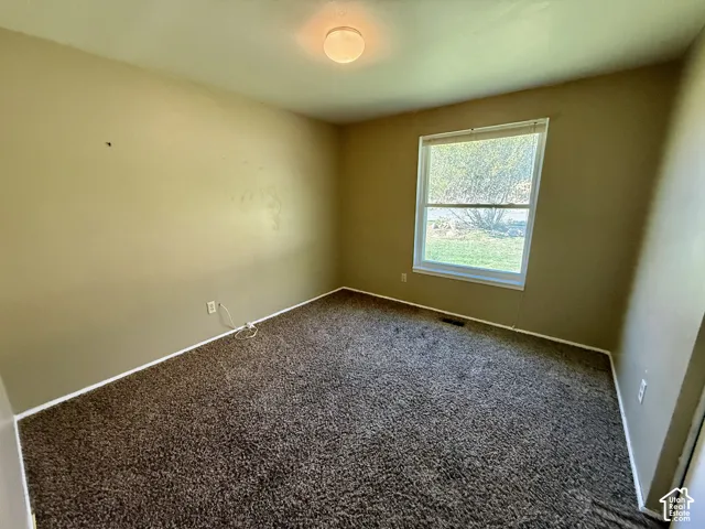 Neutral wall tones, carpeted flooring, and a flush mount ceiling fixture