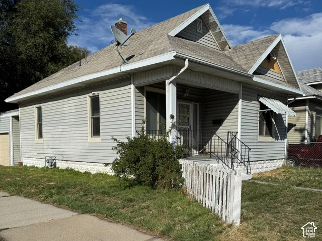 Single-story residence featuring light-colored siding, a covered porch, and a pitched roof