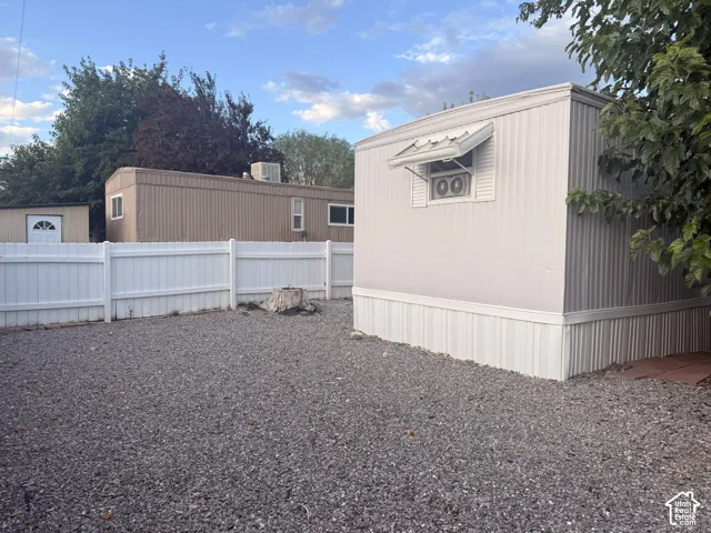 Gravel ground covering, white privacy fencing, and exterior siding