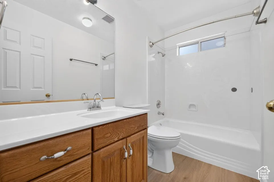 White single vanity with wood-finish cabinetry, chrome hardware, and an integrated basin