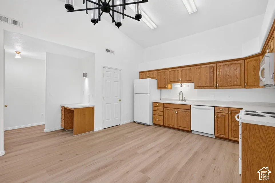 Kitchen with wood-finish cabinetry, white appliances, and light-toned countertops