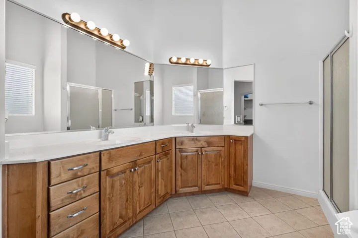 Dual vanity with wood cabinetry and undermount sinks, illuminated by vanity lighting