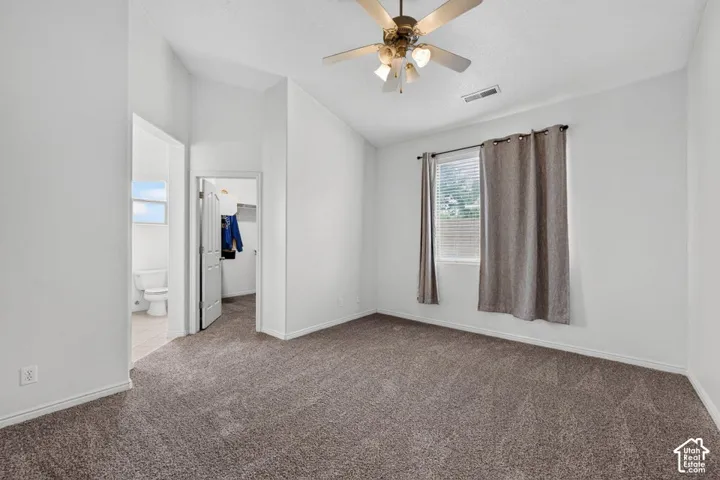 Vaulted ceiling with a ceiling fan, window with blinds, light-colored walls, and carpet flooring