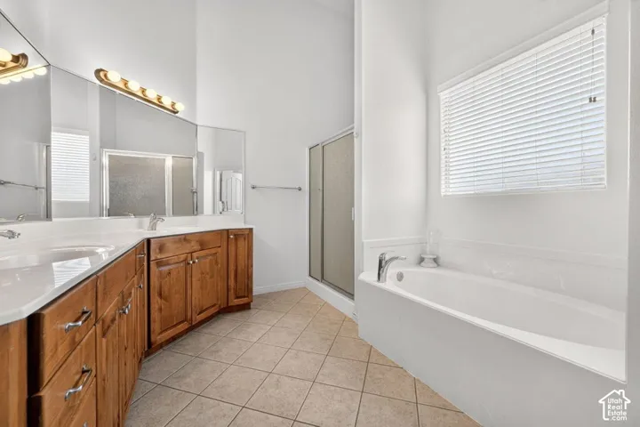 Expansive vanity with dual sinks, warm wood cabinetry, and a large mirror