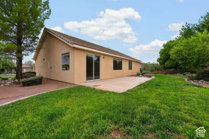 Expansive lawn area with mature trees and a concrete patio