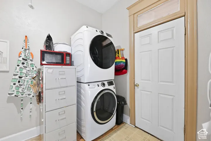 Stackable washer and dryer, white paneled door, and light wood door frame