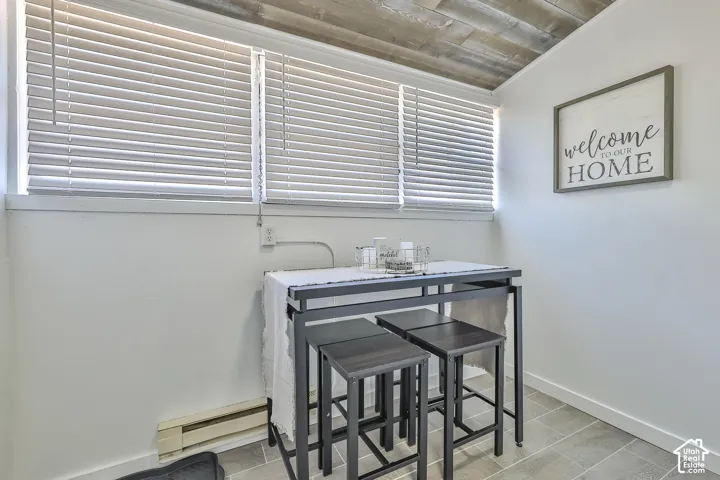 Wood-finish plank ceiling, tile flooring, and white walls