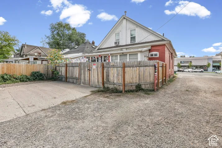 Gravel and concrete surface with a wood fence and gate