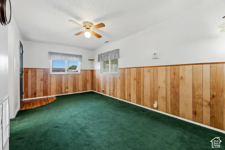 Wood-paneled walls and a ceiling fan with integrated lighting