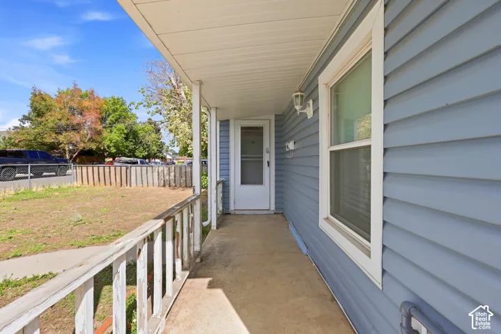 Covered front porch with composite decking and white railings, offering a sheltered entry to the home