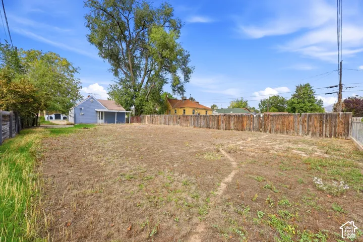 Expansive lot featuring a natural terrain, mature trees, and a privacy fence
